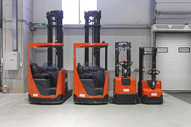 forklifts transporting large rolls of steel in a manufacturing plant